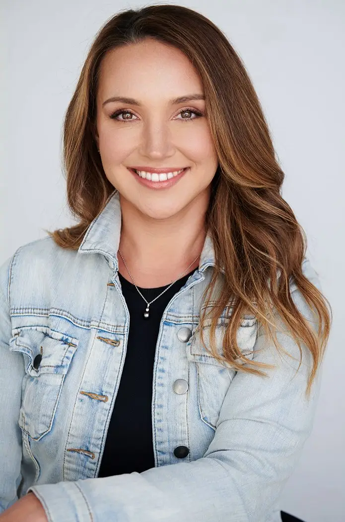 corporate headshot of brunette with jean jacket.